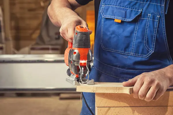 A carpenter using a jigsaw to cut wood cuts bars.