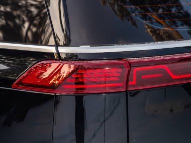 Novosibirsk, Rusya - 07 Aralık 2023: Kia Karnavalı, LED kırmızı stop lambası modern siyah geçiş aracının ayrıntılarını kapat.