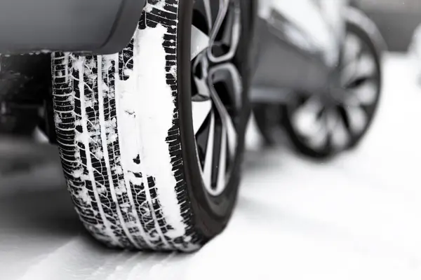 Close-up of a winter tire. Detail of car tires in winter on a road covered with snow.