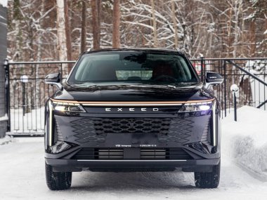 Novosibirsk, Rusya - 05 Ocak 2024: Siyah EXEED RX, kışın park edilmiş SUV, ön manzara