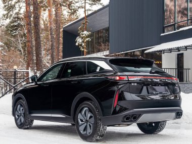 Novosibirsk, Rusya - 05 Ocak 2024: Siyah EXEED RX bir şehrin parkı. Başka araba ve insan yok.. 