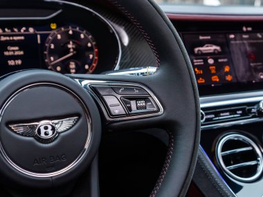 Novosibirsk, Rusya - 05 Ocak 2024: Beyaz Bentley Continental GT, fonksiyon düğmeleri olan araba direksiyonunu kapat