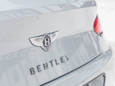 Novosibirsk, Rusya - 05 Ocak 2024: Beyaz Bentley Continental GT, Bentley logosunun beyaz araba üzerindeki yakın çekimi. 