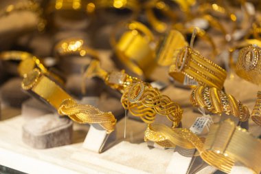 Kuyumcu vitrininde altın bilezikler, zincirler var. 