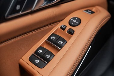 Kahverengi derili yan kapı düğmeleri: pencere ayarlama düğmeleri, kapı kilidi. 