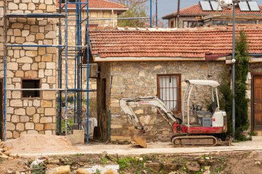 Taraf; Türkiye Şubat 04 2024: eski bir binanın yıkımı için traktör-kazıcı. Beton ve sert kaya kazıcı 