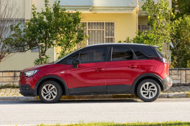 Taraf; Türkiye Şubat 04: 2024: Sıcak bir günde sokağa park edilmiş kırmızı Opel Kavşağı, bir binanın arka planına karşı. 