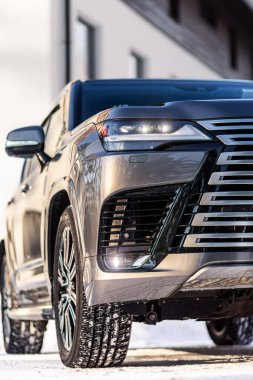 Model, araba reklamı için afiş. Gri yeni araba ön görünümü: Ksenon far, yan ayna, tampon ve kış zamanı başlık