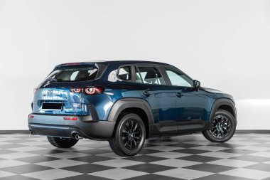 Novosibirsk, Rusya - 21 Şubat 2024: mavi Mazda CX-50 otosalonda beyaz duvara karşı, arka görüş 
