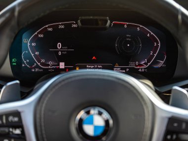 Novosibirsk, Rusya - 13 Mart 2024: BMW X7, beyaz arka ışıklandırmalı araç paneli: kilometre sayacı, hız göstergesi, takometre, yakıt seviyesi, su sıcaklığı ve daha fazlası