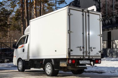 Novosibirsk, Rusya - 18 Mart 2024: Beyaz Kia Bongo, sıcak bir kış günü parka karşı sokağa park edilmiştir. 