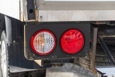 Novosibirsk, Rusya - 18 Mart 2024: Beyaz Kia Bongo, LED kırmızı stop lambalı modern gümüş arabanın ayrıntılarını kapat.