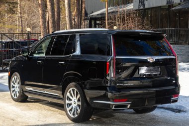Novosibirsk, Rusya - 18 Mart 2024: Siyah Cadillac Escalade, arka görüş. Kış zamanı arazi aracı park alanına karşı. 