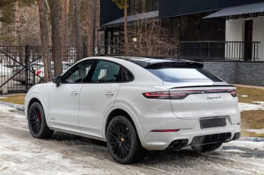 Novosibirsk, Rusya - Nisan 04, 2024: beyaz Porsche Cayenne bir şehrin parkı. Başka araba ya da insan yok.