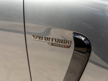 Novosibirsk, Rusya - 23 Nisan 2024: gümüş Mercedes-Benz AMG GT 63 S 4MATIC, vücutta V8 Biturbo logosu yakın plan 