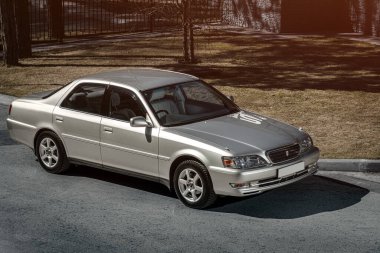 Novosibirsk, Rusya - 23 Nisan 2024: gümüş Toyota Cresta, yan görüş. Şehrin arka planında Japonya 'da yapılmış özel bir sedan.