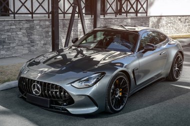 Novosibirsk, Rusya - 23 Nisan 2024: Gümüş Mercedes-Benz AMG GT 63 S 4MATIC şehrin arka planına park etti