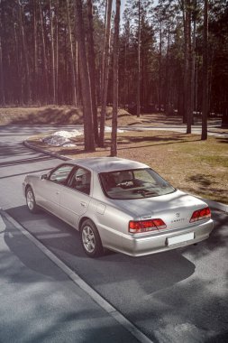 Novosibirsk, Rusya - 23 Nisan 2024: gümüş Toyota Cresta, arka manzara. Şehrin arka planında Japonya 'da yapılmış özel bir sedan.