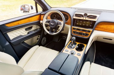 Novosibirsk, Rusya - 01 Mayıs 2024: Beyaz Bentley Bentayga, doğal deri ve ahşap kaplamalı, otomatik vitesli, modern bir geçişin lüks iç mekanı.