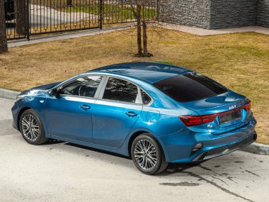 Novosibirsk, Rusya - 30 Nisan 2024: Kia K3, arka manzara, bir şehir parkı. Başka araba ve insan yok.. 