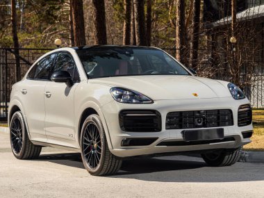 Novosibirsk, Rusya - 30 Nisan 2024: beyaz Porsche Cayenne bir şehrin parkı. Başka araba ve insan yok.. 