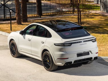 Novosibirsk, Rusya - 30 Nisan 2024: beyaz Porsche Cayenne, arka görüş. Yaz zamanı şehre karşı SUV arabası 