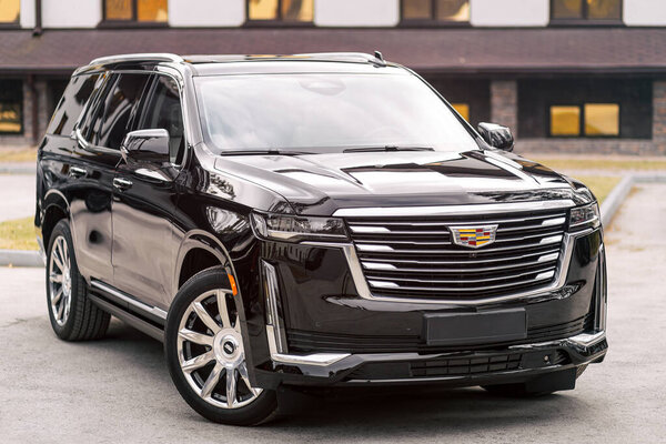 Novosibirsk, Russia -  April 30  , 2024:  black  Cadillac Escalade 600 ,  front  view. SUV   car  against city in  summer time 