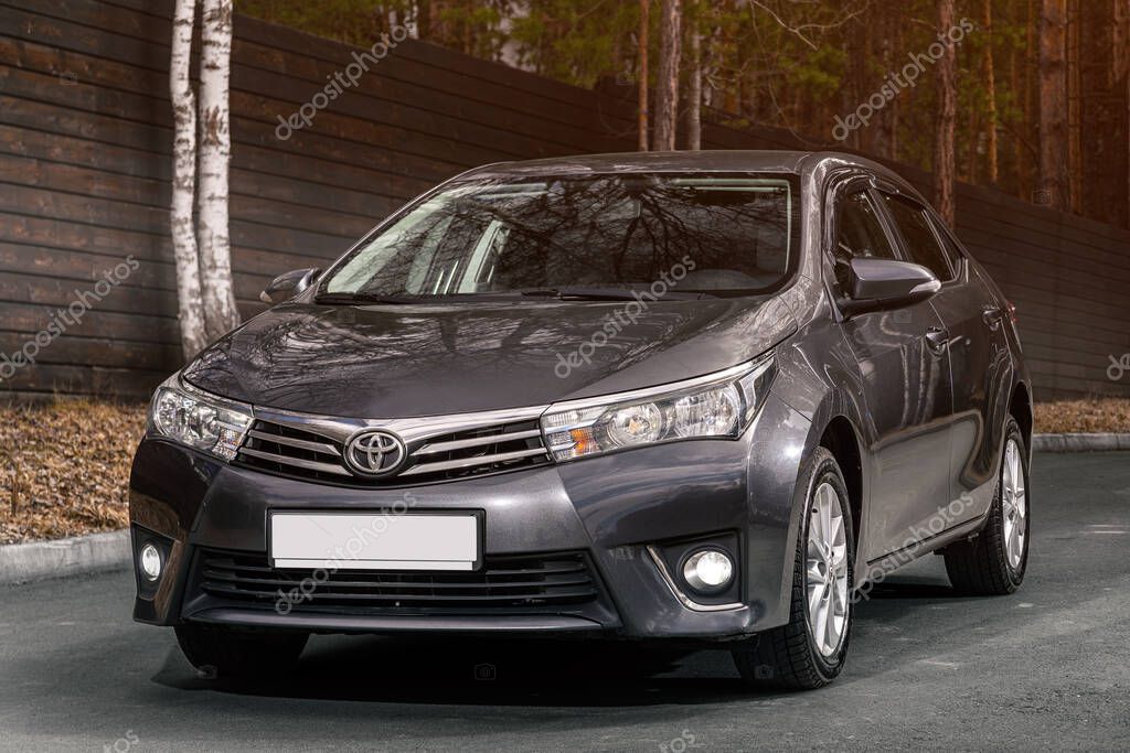 Novosibirsk, Russia -  May 05  , 2024:   gray   Toyota Corolla ,  front  view. SUV   car  against city in  summer time