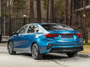 Novosibirsk, Rusya - 30 Nisan 2024: Kia K3, arka manzara, bir şehir parkı. Başka araba ve insan yok.. 