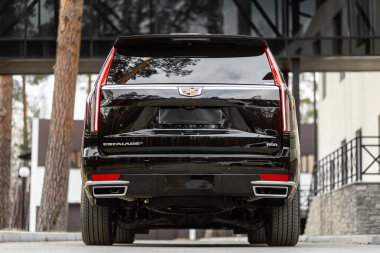 Novosibirsk, Russia -  April 30  , 2024:  black  Cadillac Escalade 600,  back   view, parked of a city. No other car and people.  clipart
