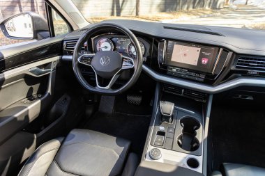 Novosibirsk, Russia -  April 13  , 2024: gray  Volkswagen Touareg , Interior of new modern SUV car with steering wheel, shift lever and dashboard, climate control, speedometer, display clipart