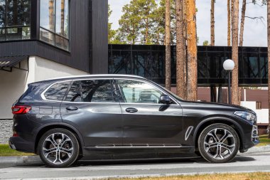 Novosibirsk, Rusya - 15 Mayıs 2024: Siyah BMW X5 bir yaz günü caddeye park edilmiş, şehrin arka planına karşı, yan manzara