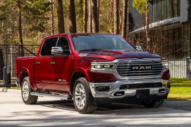 Novosibirsk, Rusya - 15 Mayıs 2024: Kırmızı Dodge Ram 1500 LongHorn, pikap yaz zamanı park halinde, ön manzara