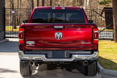 Novosibirsk, Rusya - 15 Mayıs 2024: Kırmızı Dodge Ram 1500 LongHorn, pikap yaz zamanı park halinde, arka manzara