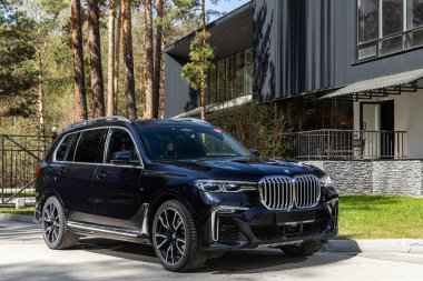 Novosibirsk, Rusya - 15 Mayıs 2024: Siyah BMW X7 yaz mevsiminde park halinde, ön manzara