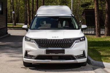 Novosibirsk, Rusya - Haziran 01, 2024: Beyaz Kia Karnavalı bir şehrin parkında. Başka araba ve insan yok.. 