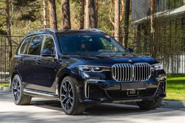 Novosibirsk, Rusya - 15 Mayıs 2024: Siyah BMW X7, şehirde park edilmiş SUV, ön manzara