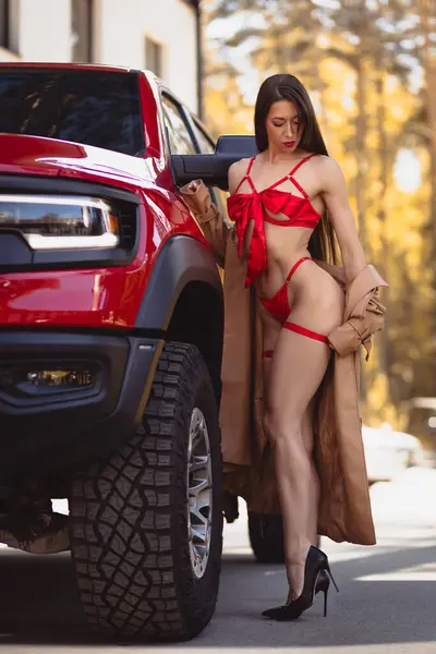 stock image Young woman fitness model in swimsuit posing for advertising a luxury  car 