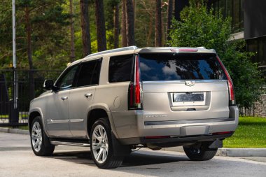 Novosibirsk, Rusya - 10 Temmuz 2024: Cadillac Escalade, şehirde park edilmiş, arka manzara