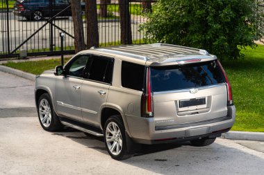 Novosibirsk, Rusya - 10 Temmuz 2024: Cadillac Escalade, sıcak bir yaz gününde park alanına park etti 
