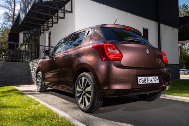 Novosibirsk, Rusya - 10 Temmuz 2024: Suzuki Swift, şehirde park edilmiş, arka manzara