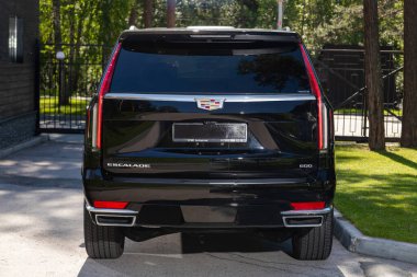 Novosibirsk, Rusya - 10 Temmuz 2024: Cadillac Escalade, şehirde park edilmiş, arka manzara