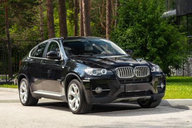 Novosibirsk, Rusya - 10 Temmuz 2024: BMW X6, şehirde park edilmiş, ön manzara