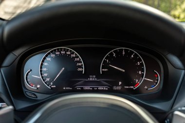 Yuvarlak gösterge paneli, hız göstergesi ve takometreye beyaz ışık altında yakın çekim. modern araba interio