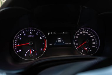 Yuvarlak gösterge paneli, hız göstergesi ve takometreye beyaz ışık altında yakın çekim. modern araba interio