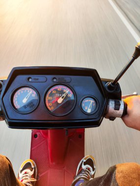 Motosikletle sürat yapan adama yakın, takometreyle hız göstergesi