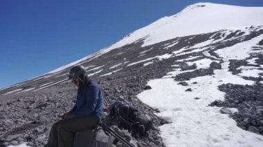 Pico de Orizaba buzulunun dibinde oturan bir dağcı.