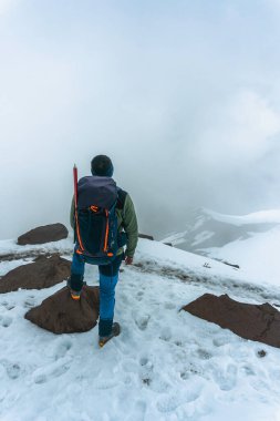 Dağlarda trekking sırt çantası olan adam. Soğuk hava, kar tepelerde. Hiking kış.