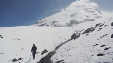 Dağlarda trekking sırt çantası olan adam. Soğuk hava, kar tepelerde. Hiking kış.