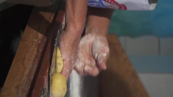 パン屋さんの木製テーブルでパン生地を準備する男 — ストック動画